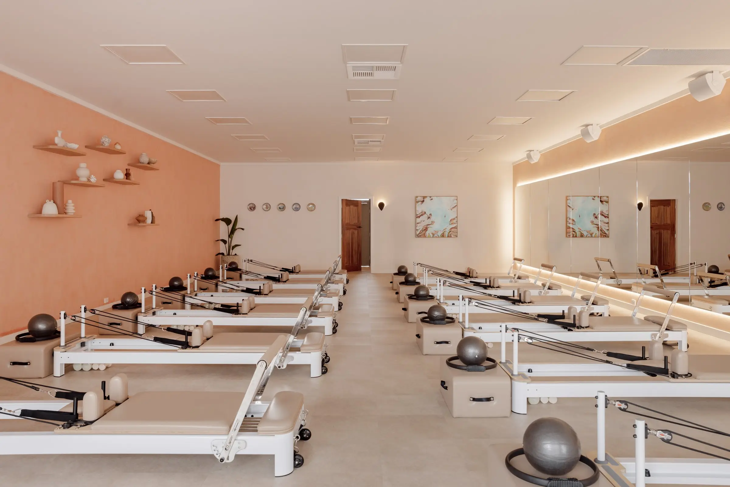 The Sento Club studio in Lambton: terracotta wall, shelves of ceramics and two rows of reformers
